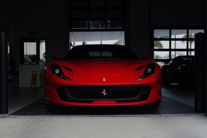 Czerwone Ferrari sportowe zaparkowane w nowoczesnym garażu Czerwone Ferrari sportowe zaparkowane w nowoczesnym garażu