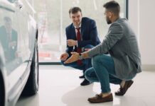 Który Hyundai sprawdzi się jako auto firmowe: porównujemy i30, Tucson i i40 Dwóch mężczyzn ogląda wyposażenie Hyundaia w salonie samochodowym