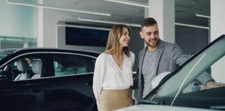 Uśmiechnięta para ogląda nowe Volvo w salonie samochodowym