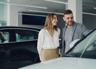 Uśmiechnięta para ogląda nowe Volvo w salonie samochodowym