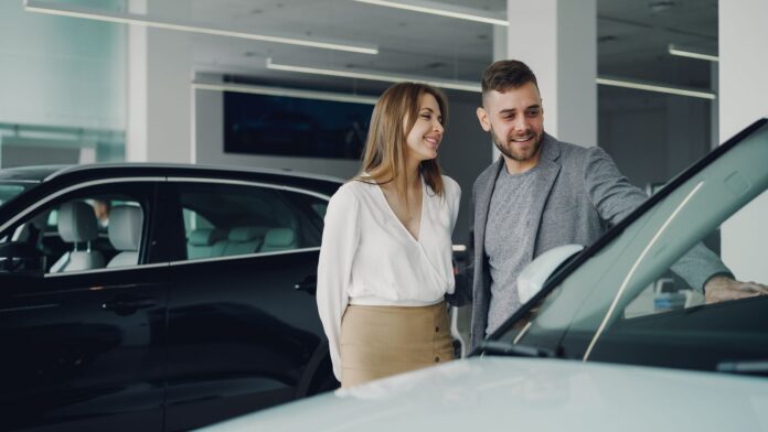 Uśmiechnięta para ogląda nowe Volvo w salonie samochodowym