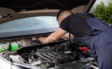 Mechanik serwisuje silnik samochodu w warsztacie Mercedesa