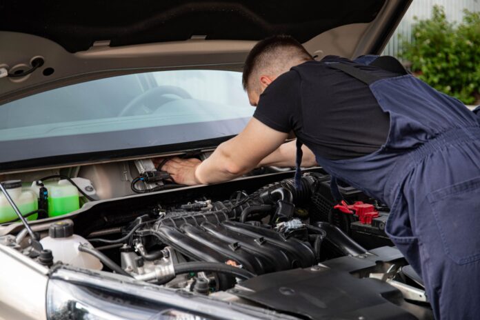 Mechanik serwisuje silnik samochodu w warsztacie Mercedesa