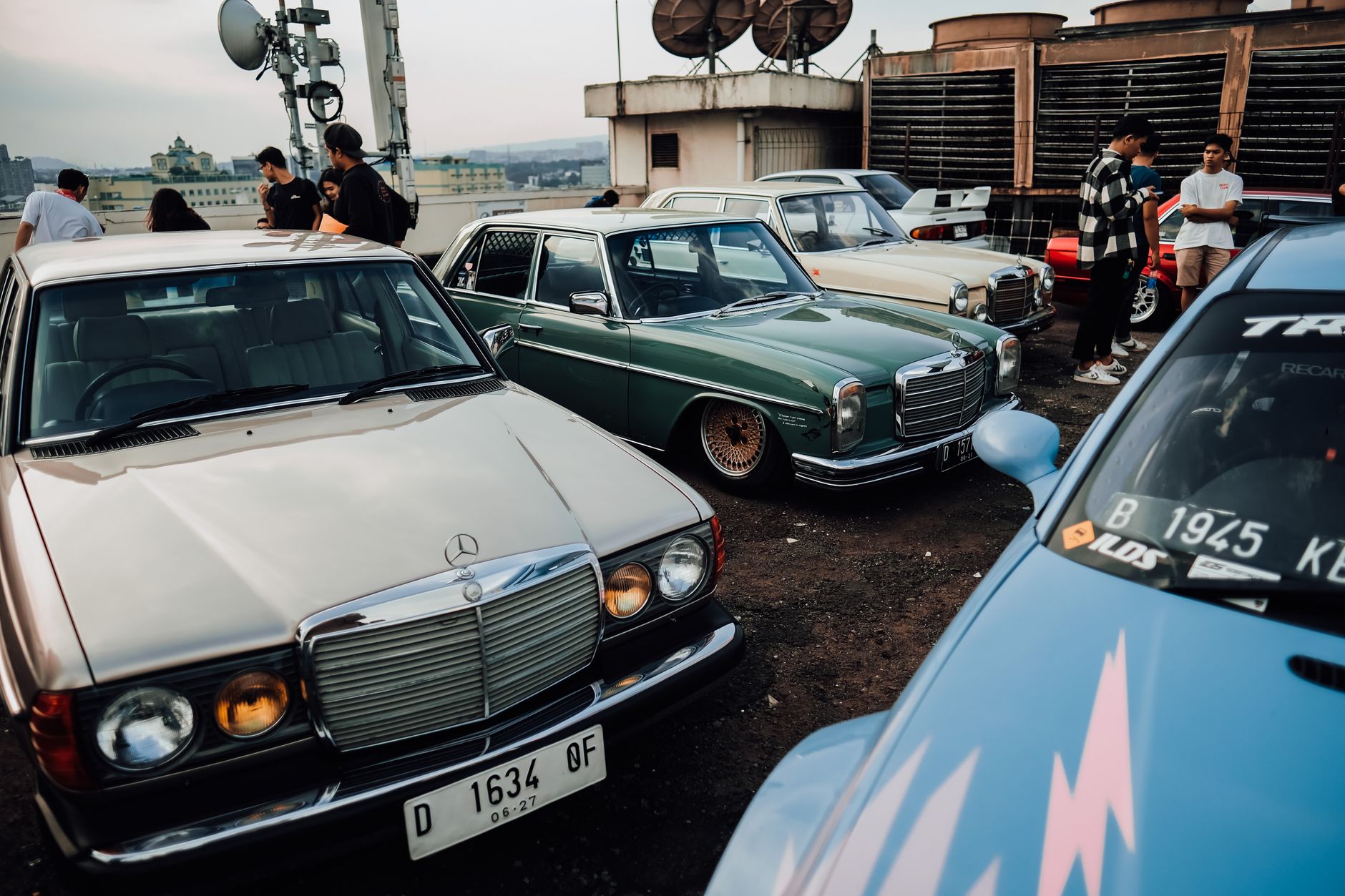 Zlot klasycznych BMW na dachu parkingu, fani oglądają auta
