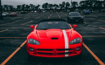 Czy ubezpieczenie Ferrari musi być drogie – porównanie ofert OC, AC i pakietów kolekcjonerskich Czerwone Ferrari zaparkowane na pustym parkingu pod zachmurzonym niebem