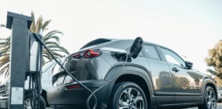 Nowoczesny Jeep plug-in hybrid podłączony do ładowarki na zewnątrz