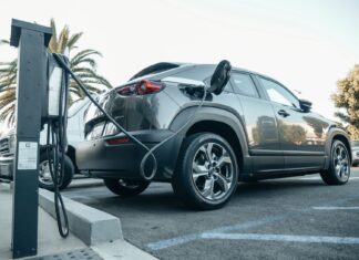 Nowoczesny Jeep plug-in hybrid podłączony do ładowarki na zewnątrz