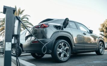 Jeep Plug-in Hybrid, realne spalanie, wady i zalety hybrydowych wersji 4xe w mieście Nowoczesny Jeep plug-in hybrid podłączony do ładowarki na zewnątrz