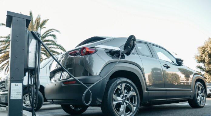 Jeep Plug-in Hybrid, realne spalanie, wady i zalety hybrydowych wersji 4xe w mieście Nowoczesny Jeep plug-in hybrid podłączony do ładowarki na zewnątrz