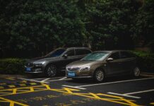 SUV i sedan zaparkowane obok siebie na zacienionym parkingu miejskim