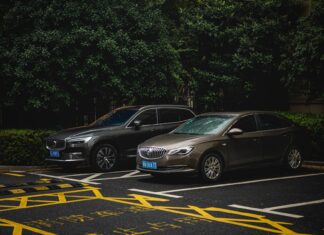 SUV i sedan zaparkowane obok siebie na zacienionym parkingu miejskim